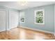This well lit bedroom features two windows, light blue walls, a modern chandelier, and hardwood floors at 1134 Willow Oaks Trl, Matthews, NC 28104