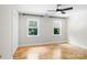 Bright bedroom features two windows, neutral walls, a ceiling fan, and beautiful hardwood floors at 1134 Willow Oaks Trl, Matthews, NC 28104