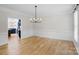 Bright dining room with hardwood floors, decorative lighting, and access to the kitchen at 1134 Willow Oaks Trl, Matthews, NC 28104