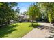 Brick home with a long driveway, surrounded by a lush green lawn and mature trees at 1134 Willow Oaks Trl, Matthews, NC 28104