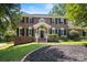 Beautiful two-story brick home with a well-maintained lawn and classic architectural details at 1134 Willow Oaks Trl, Matthews, NC 28104