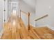 Hallway with hardwood floors, stairway, and white railing leading to the upper level at 1134 Willow Oaks Trl, Matthews, NC 28104