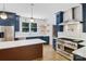 Open kitchen features stainless appliances, custom backsplash, a large island, and blue cabinets at 1134 Willow Oaks Trl, Matthews, NC 28104