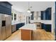 Gourmet kitchen boasts stainless appliances, custom blue cabinets, and a large island with quartz countertops at 1134 Willow Oaks Trl, Matthews, NC 28104