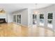 Bright living room features a fireplace, hardwood floors, and double french doors to the outside deck and pool at 1134 Willow Oaks Trl, Matthews, NC 28104