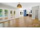 Spacious living room with hardwood floors, double french doors to the outside deck, and a view into the kitchen at 1134 Willow Oaks Trl, Matthews, NC 28104
