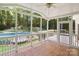 Screened-in porch features tile flooring, a ceiling fan, and views of the pool at 1134 Willow Oaks Trl, Matthews, NC 28104