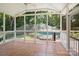 Screened-in porch with tile flooring overlooks a pool and lush green backyard at 1134 Willow Oaks Trl, Matthews, NC 28104