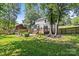 Large, well-manicured backyard with patio, mature trees, and fenced perimeter at 11401 Lone Star Cir, Charlotte, NC 28226