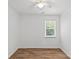 A well-lit bedroom has hardwood flooring, a ceiling fan, a window with blinds, and white walls at 11401 Lone Star Cir, Charlotte, NC 28226