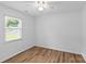 This bedroom has light hardwood flooring, a ceiling fan, a window with blinds, and white walls at 11401 Lone Star Cir, Charlotte, NC 28226