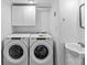 A bright laundry room features a Whirlpool washer and dryer with white cabinets and a sink at 11401 Lone Star Cir, Charlotte, NC 28226