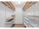 A walk-in closet offers white shelving with brown wood trim and plank flooring at 11401 Lone Star Cir, Charlotte, NC 28226
