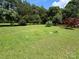 Large, level green backyard with lush green grass, trees around the edges, and a wooden fence in the background at 13221 Brandywine Ln, Midland, NC 28107