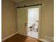 Bathroom showcasing a sliding barn door, tiled floors, a toilet, and a shower-tub combination at 13221 Brandywine Ln, Midland, NC 28107