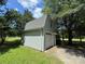 View of the detached garage with a white garage door, a side door, and a large window above the garage door at 13221 Brandywine Ln, Midland, NC 28107