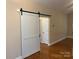 Hallway featuring hardwood floors and a sliding barn door leading to another room at 13221 Brandywine Ln, Midland, NC 28107