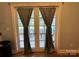This patio door leads to an outdoor space, framed by stylish curtains at 13221 Brandywine Ln, Midland, NC 28107