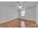 An empty bedroom with hardwood floors, a ceiling fan, and a window with white curtains at 137 Proust Rd, Statesville, NC 28625