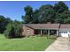 Charming brick home featuring a well-manicured lawn, mature trees, and inviting curb appeal at 137 Proust Rd, Statesville, NC 28625