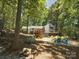 A spacious backyard featuring a wooden deck and a fire pit area with blue Adirondack chairs surrounded by trees at 1711 Apple Tree Ln # 28, Fort Mill, SC 29715