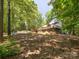 Backyard featuring a spacious deck and a fire pit area with blue Adirondack chairs, all surrounded by lush trees at 1711 Apple Tree Ln # 28, Fort Mill, SC 29715
