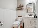 Cozy half bath with white wainscoting, wooden shelves and classic fixtures at 1711 Apple Tree Ln # 28, Fort Mill, SC 29715