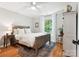 Inviting bedroom with hardwood floors, soft lighting, and a view of the surrounding greenery at 1711 Apple Tree Ln # 28, Fort Mill, SC 29715