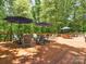 Large wooden deck with multiple seating areas and umbrellas, set amidst a lush green forest at 1711 Apple Tree Ln # 28, Fort Mill, SC 29715