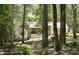 Secluded two-story home with a stone-accented front and gray painted siding nestled amongst mature trees at 1711 Apple Tree Ln # 28, Fort Mill, SC 29715
