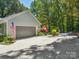 A detached two car garage framed by lush landscaping, an American flag and long driveway at 1711 Apple Tree Ln # 28, Fort Mill, SC 29715