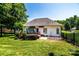 Well-maintained backyard featuring a wooden deck, lush lawn, mature trees, and a black metal fence at 2124 Congress Ct, Kannapolis, NC 28083