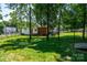 Spacious backyard with a well-manicured lawn, mature trees, black fence, and a glimpse of the neighboring house at 2124 Congress Ct, Kannapolis, NC 28083