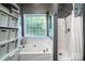 Relaxing bathroom featuring a bathtub, shower, and glass block window allowing natural light to illuminate the space at 2124 Congress Ct, Kannapolis, NC 28083