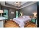 Relaxing bedroom featuring a tray ceiling, neutral walls, hardwood floors, and a comfortable bed with pink bedding at 2124 Congress Ct, Kannapolis, NC 28083