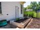 Exterior shot of a raised garden bed with decorative plants, a black fence, and an adjacent home at 2124 Congress Ct, Kannapolis, NC 28083