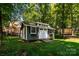 Charming outbuilding nestled in the backyard, perfect for storage or a hobby space, surrounded by trees at 2124 Congress Ct, Kannapolis, NC 28083