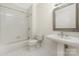 Clean, classic bathroom featuring white tile, a shower-tub combo, and a pedestal sink for a timeless aesthetic at 229 N Church St # 100, Charlotte, NC 28202