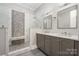 Modern bathroom featuring a double vanity and a glass-enclosed shower with stylish tile and a built-in bench at 229 N Church St # 100, Charlotte, NC 28202