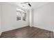 Bright bedroom with a large window, ceiling fan, and beautiful hardwood floors, creating a cozy and inviting space at 229 N Church St # 100, Charlotte, NC 28202