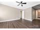 Bright and airy bedroom with ceiling fan, hardwood floors, and an open doorway to an ensuite bathroom at 229 N Church St # 100, Charlotte, NC 28202