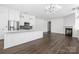 Open-concept living space with dark floors, fireplace, island, and stainless steel appliances at 229 N Church St # 100, Charlotte, NC 28202