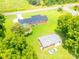 The aerial perspective captures the house with a garage and car, all surrounded by green lawns and tall trees at 24132 Nc Hwy 73 Hwy, Albemarle, NC 28001