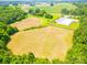 Aerial view of land for sale with open fields surrounded by trees and vegetation at 24132 Nc Hwy 73 Hwy, Albemarle, NC 28001