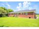 A sprawling back yard with a brick house, mature trees, and a well-maintained lawn at 24132 Nc Hwy 73 Hwy, Albemarle, NC 28001