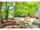 Backyard with deck, mature trees, wood fence, and a mix of landscaped areas, offering privacy at 2830 Grosbeak Ln, Charlotte, NC 28269