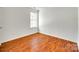 Bedroom featuring hardwood floors and a large window at 2830 Grosbeak Ln, Charlotte, NC 28269