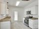 Well-lit kitchen featuring white cabinets, stainless steel appliances, and granite countertops, modern and functional at 2830 Grosbeak Ln, Charlotte, NC 28269