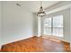Bright living room featuring hardwood floors, a large window, and a modern chandelier at 2830 Grosbeak Ln, Charlotte, NC 28269