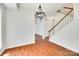 Open living room with hardwood floors, staircase with white banister and entry doorway at 2830 Grosbeak Ln, Charlotte, NC 28269